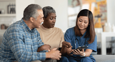 photo of two adults talking to a nurse or medical professional