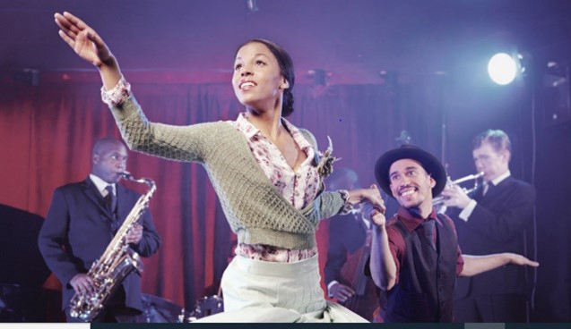 A black woman and black man dancing and smiling at a jazz club in Southwestern Pennsylvania.
