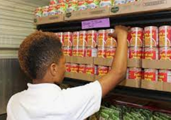 A black person selecting canned goods at the Second Harvest Food Bank School Pantry Program (Northwestern Pennsylvania)