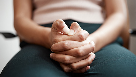 Close-up of a person's hands that are together and nervous to illustrate anxiety warning signs.