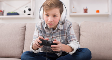 photo of a child on the couch playing video games