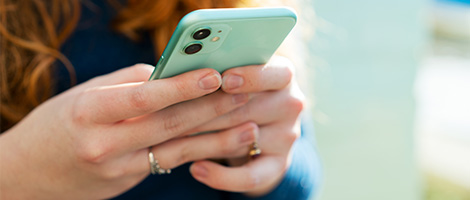 Close-up of a person on a mobile phone searching for mental health treatments.