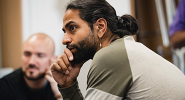 Adult male listening to a conversation at a substance use disorder meeting.